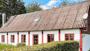 A traditional white building with red window frames and a tiled roof. - 5 Person Holiday Home in Nexo (Nexø)