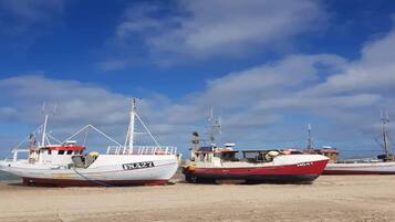 Dos barcos amarrados en un puerto deportivo, bajo un cielo despejado.