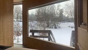 A room with a large window overlooking a snowy landscape.