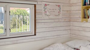 A bedroom with a bed, a window, and a bookshelf. - 4 Star Holiday Home in Sturko (Sturkö)