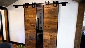 Una stanza con parete in legno, una porta scorrevole e un cartello con scritto 'ANTQUES'.