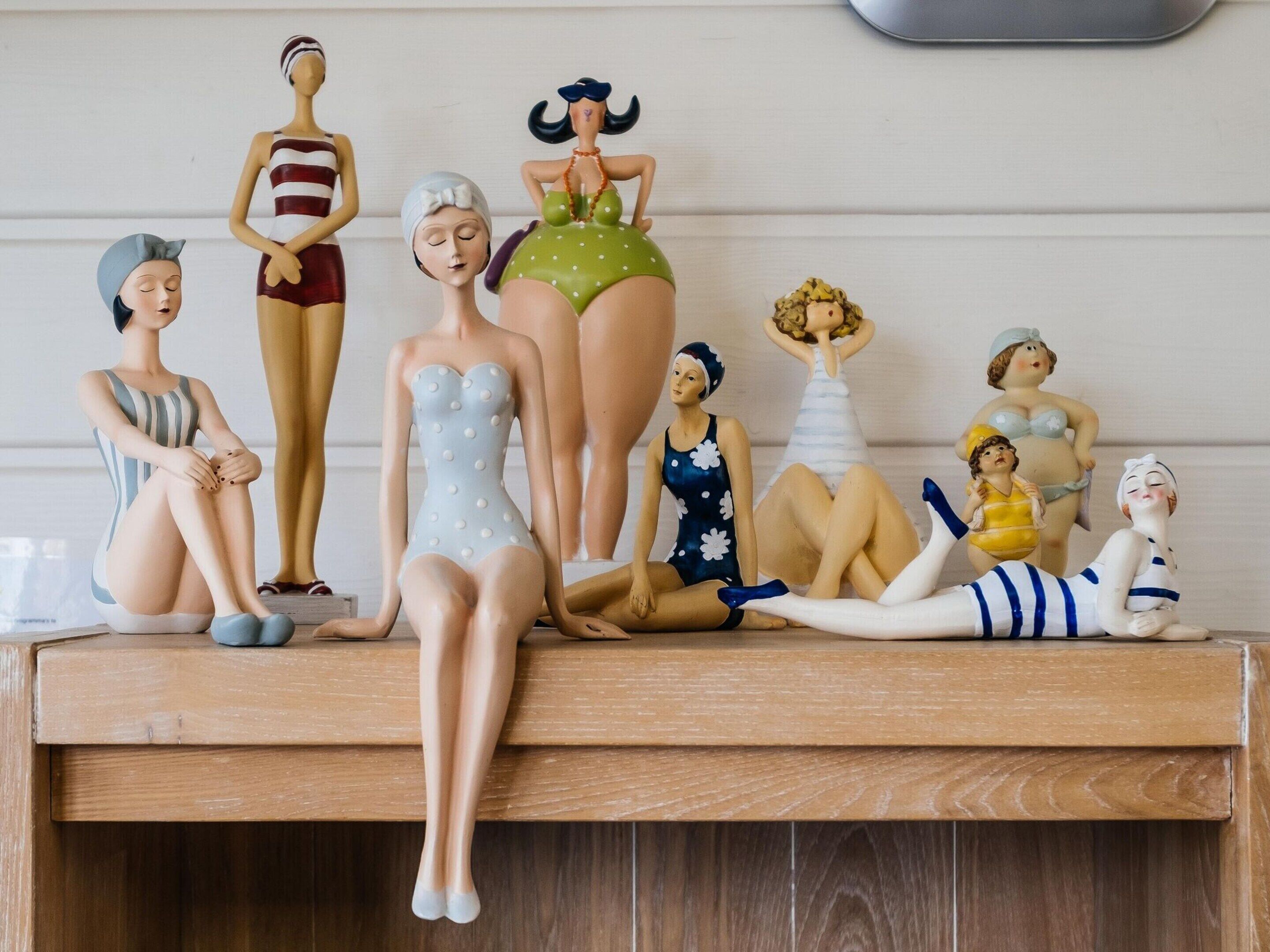 Una colección de figuras sobre un estante de madera.