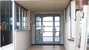 A narrow hallway with a glass door leading to a room. - Apartment in Nieuwpoort Near the Beach (Nieuwpoort)