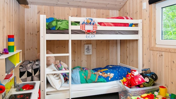 A bunk bed room with a basketball hoop, storage shelves, and a window with a view of greenery. - 4 Person Holiday Home in Oksbol (Oksbol)