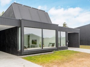 A modern building with large windows and a sloped roof. - 4 Person Holiday Home in Gilleleje (Gilleleje)