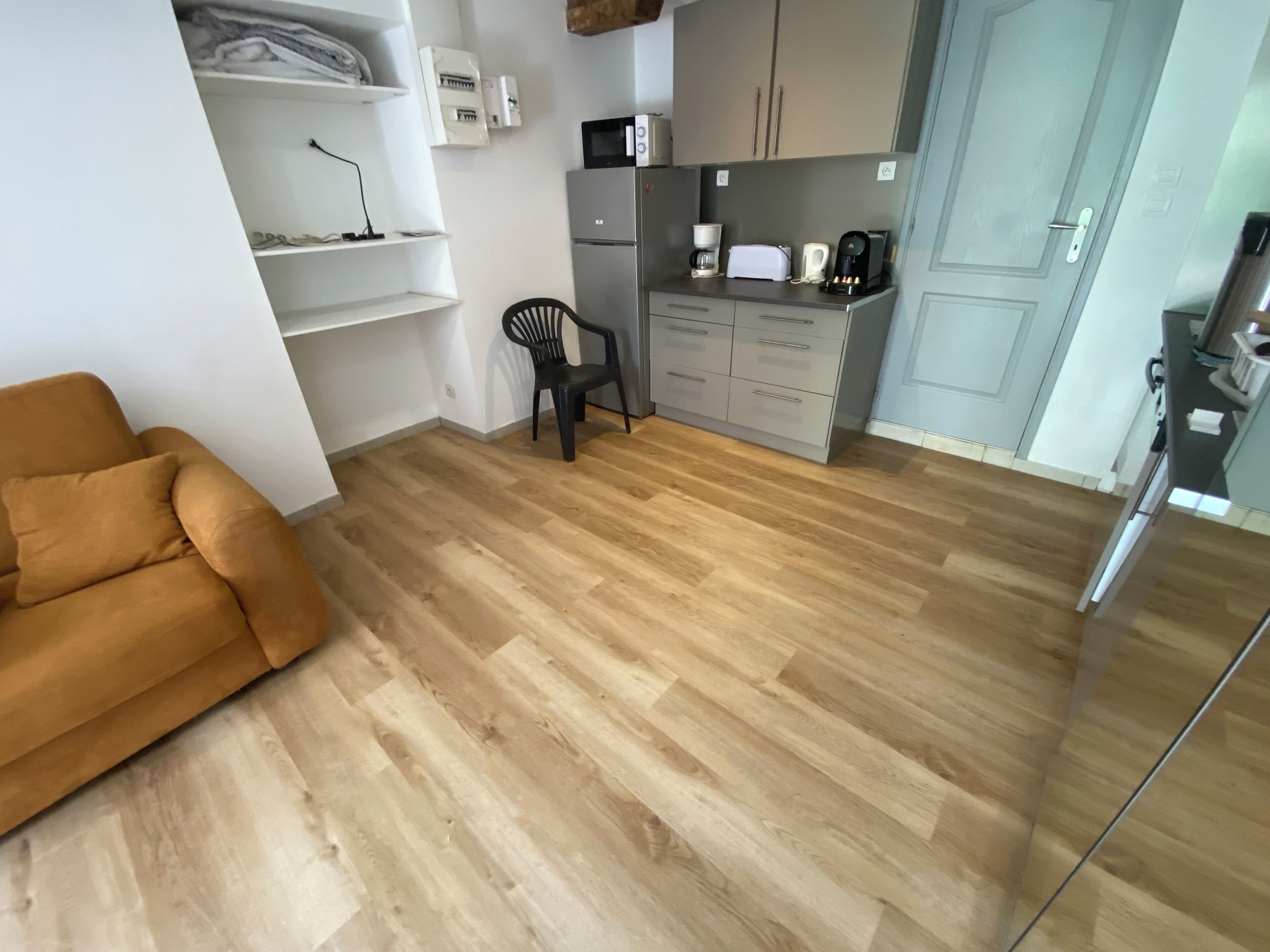 A compact living space with a sofa, a kitchenette, and a dining area.