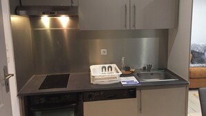 A compact kitchen with stainless steel appliances, a dishwasher, and a sink. - Orry D'oriège, Studio de Plain-pied, Centre Ville AX, Label "Ax Qualité Confort" (Ax-les-Thermes)