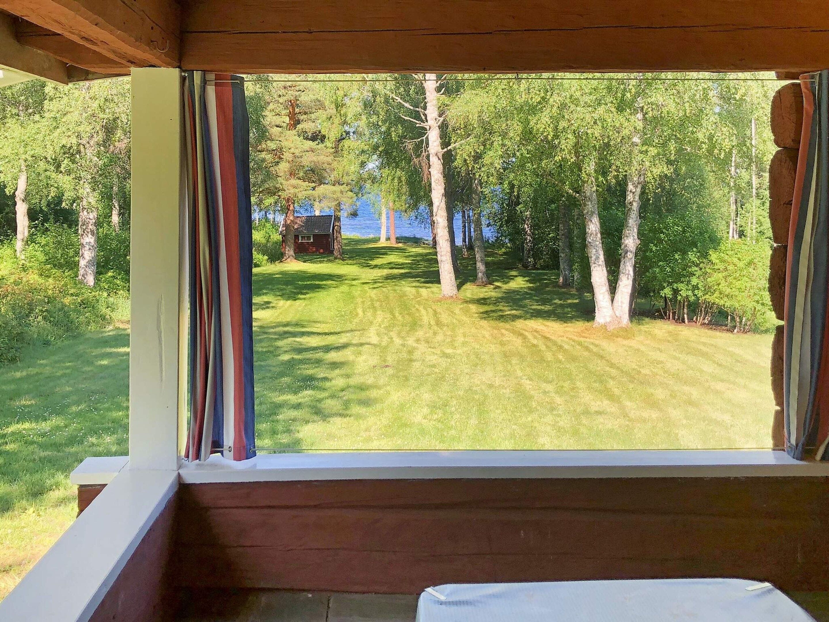 A room with a view of a grassy area and trees.