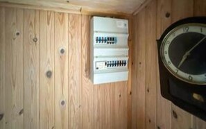 A wooden wall with a clock and electrical panel. - 5 Person Holiday Home in Asaa (Asaa)