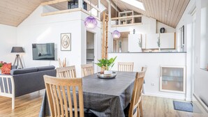 A modern living space with a dining area, kitchen, and loft bedroom. - 6 Person Holiday Home in Tarm (Hemmet)