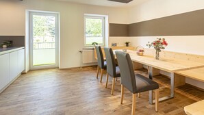 A modern kitchen with a wooden dining table, four chairs, and a window. - Apartment in Alps With Stunning Views (Eisenerz)