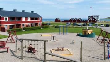 A playground with swings, a climbing structure, and a sandbox.
