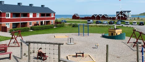 A playground with swings, a climbing structure, and a sandbox.