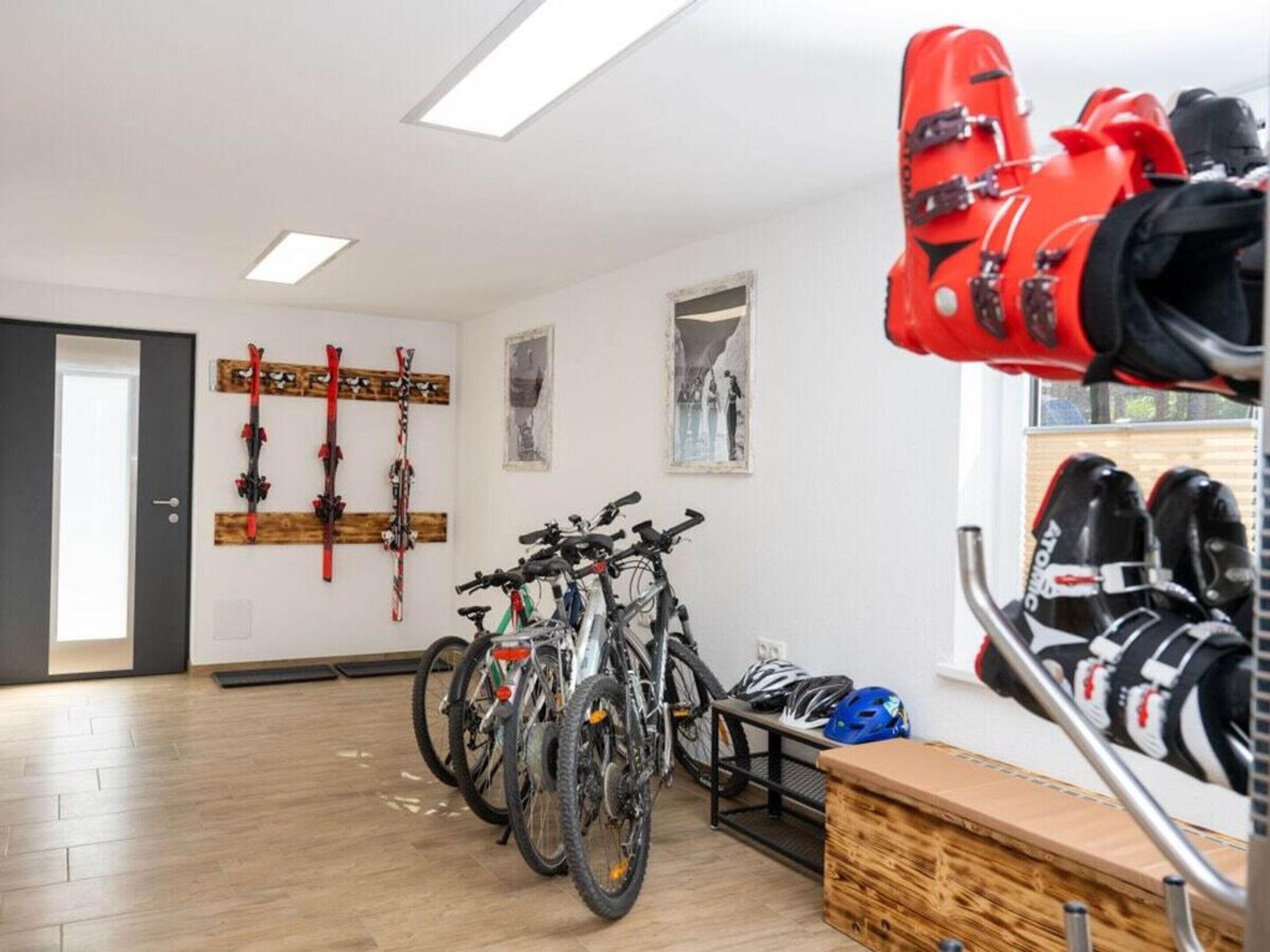 Una habitación con bicicletas, cascos y esquíes en portaequipajes.