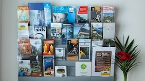 A bulletin board with various printed materials pinned to it, including brochures and flyers. - Present Apartment in Fusch (Fusch an der Grossglocknerstrasse)