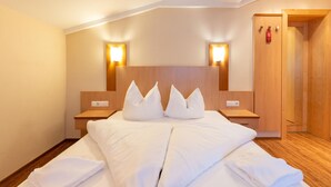 A hotel room with a large bed, wooden headboard, bedside tables, and wall-mounted lights. - Apartment in Langenfeld With Recreation Room (Laengenfeld)