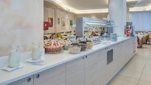 A modern buffet setup with various food items and a central serving station. - Apartment in Caorle Near the Beach (Caorle)