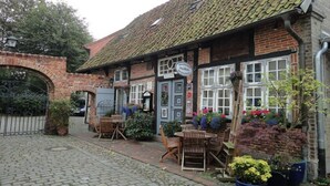 A traditional pub with a brick facade, a tiled roof, and outdoor seating. - Houseboat Grey Seal Comfortable Vacation Home (Heiligenhafen)