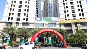 A high-rise building with multiple floors and a large archway at the entrance. - Happy Home (Quan Trieu)