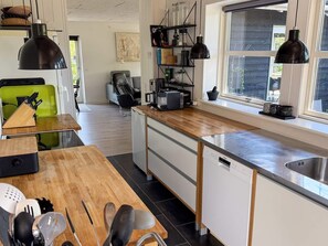 A modern kitchen with a wooden countertop, a built-in dishwasher, and a window with a view. - 4 Person Holiday Home in Ebeltoft (Ebeltoft)
