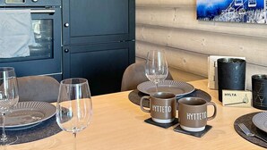 A dining table set with plates, glasses, and two mugs labeled "HYTTETID".
