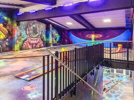 Una habitación temática del espacio con un mural, una escalera y un tobogán.