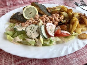 A plate of food with a salad, roasted potatoes, and a slice of bread. - Henny Modern Retreat (Jemgum)