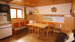 Una cocina acogedora con muebles de madera, una mesa de comedor y un banco.