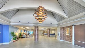 A spacious lobby with a high ceiling, a central spiral chandelier, and a reception desk. - Oceanfront Balcony | 1BR  | Pools |Hot Tubs (Daytona Beach)