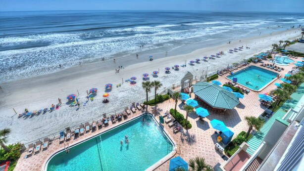 A resort with a large pool, beach area, and multiple umbrellas. - Oceanfront Balcony | 1BR  | Pools |Hot Tubs (Daytona Beach)