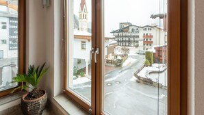 A room with a large window overlooking a snowy street and a church steeple. - Pleasant Apartment in Langenfeld With Garden (Laengenfeld)