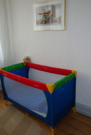 A playpen with a colorful border and a small stuffed animal inside. - Arndt in the old Town (Lübeck)