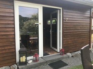 A wooden house with a sliding glass door, number 7, and two lanterns outside. - Holiday Home Lower Lake Terrace (Rieden)
