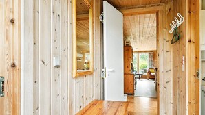 Un interior de madera con un pasillo que conduce a un comedor.