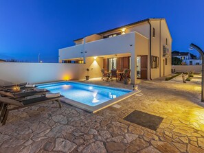 A modern two-story house with a swimming pool, stone patio, and outdoor seating area. - Family Villa With Pool, Wellness (Vodnjan)