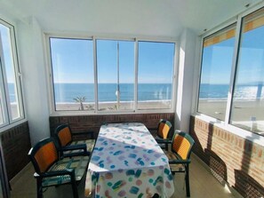 Enjoy a meal with a view of the ocean from this room's corner table, surrounded by four chairs.