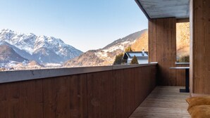 Eine Holzterrasse mit Blick auf schneebedeckte Berge.