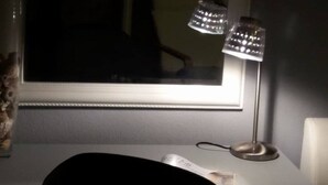 Une pièce avec un bureau, une lampe et une fenêtre.