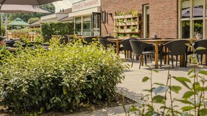 An outdoor café with brick walls, wooden tables, and chairs. - Starlit Tent Lodge Escape (Zuna)