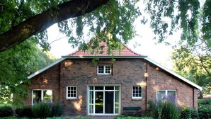 A brick building with a gabled roof, large windows, and a front door. - Appealing Apartment in Westerstede (Westerstede)