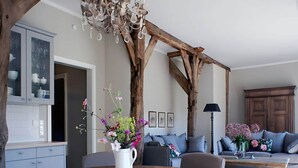 A modern living room with a wooden dining table, a sofa set, and a chandelier. - Appealing Apartment in Westerstede (Westerstede)