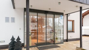 A modern building entrance with a glass door, a metal sculpture, and a paved area. - Nice Apartment in Langenfeld With Sauna (Laengenfeld)