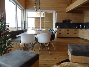 A modern kitchen with wooden cabinets, a dining table with chairs, and a Christmas tree. - Huttenzauber 3 Comfortable Holiday Residence (Annaberg-Lungoetz)