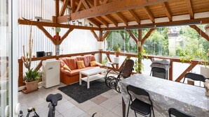 An outdoor patio area with a wooden ceiling, a sofa, a table, and chairs. - Sauna Retreat in Sulz (Sulz am Neckar)