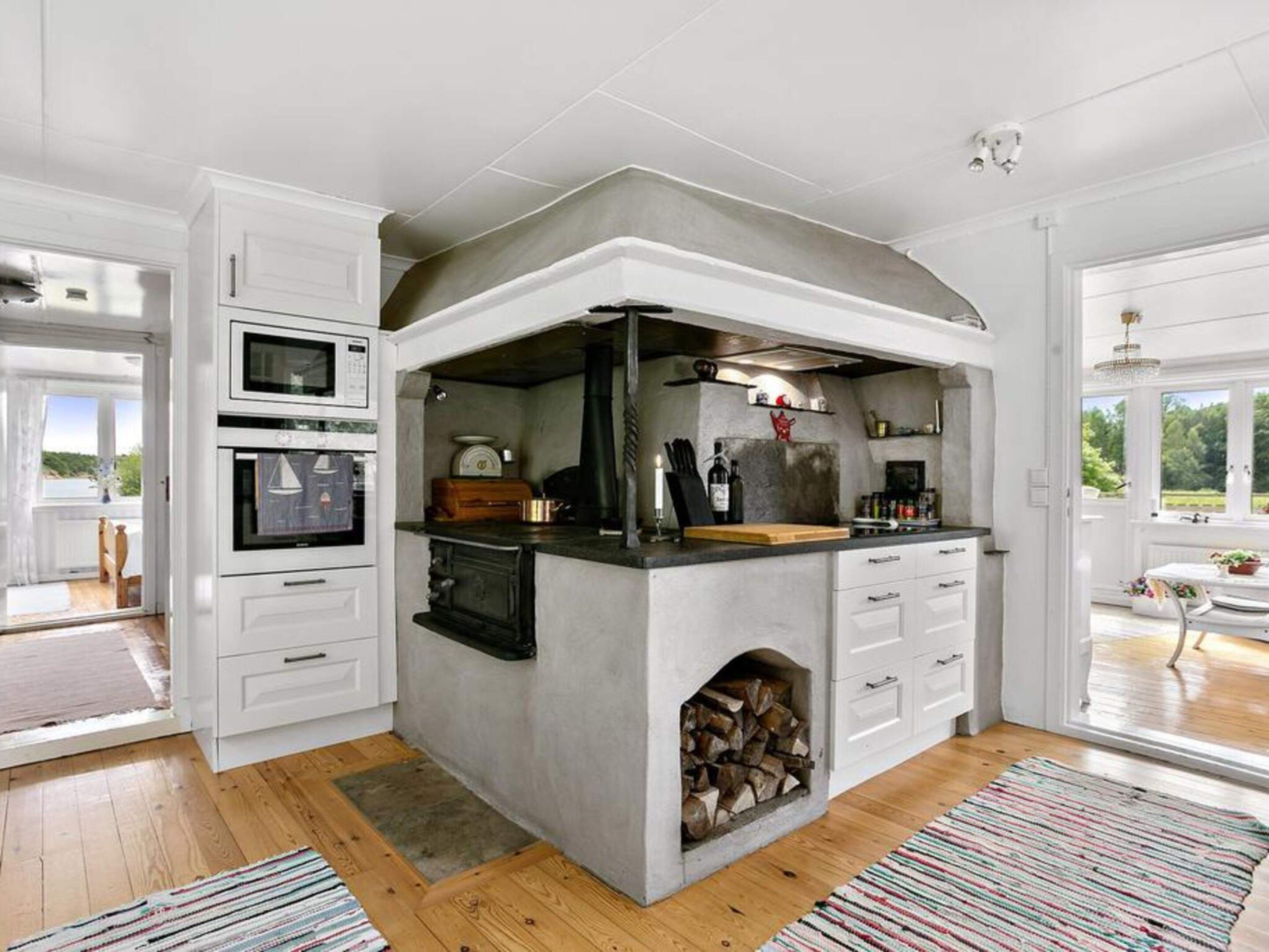 A kitchen with a built-in stove, oven, and a fireplace.