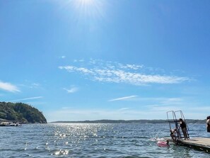 A lake with a dock, boats, and people. - 4 Person Holiday Home in Uddevalla (Uddevalla)