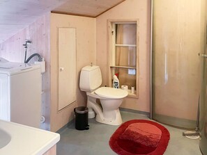 A compact bathroom with a toilet, sink, and window. - 4 Person Holiday Home in Uddevalla (Uddevalla)