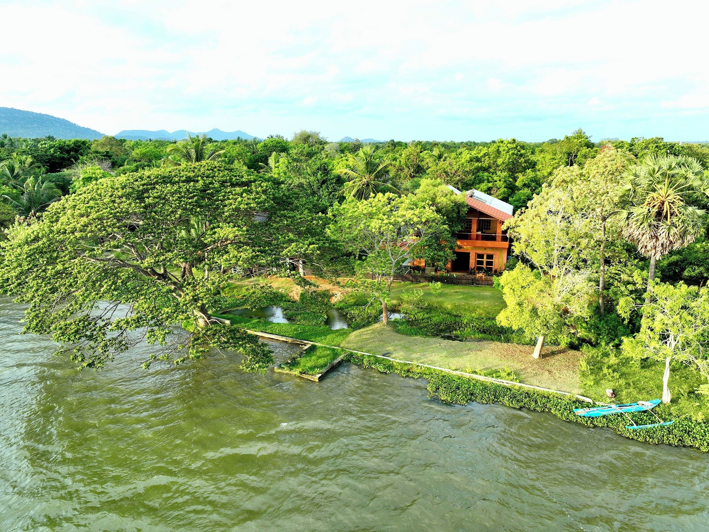 Ein Haus, umgeben von üppiger Vegetation und einem Fluss.