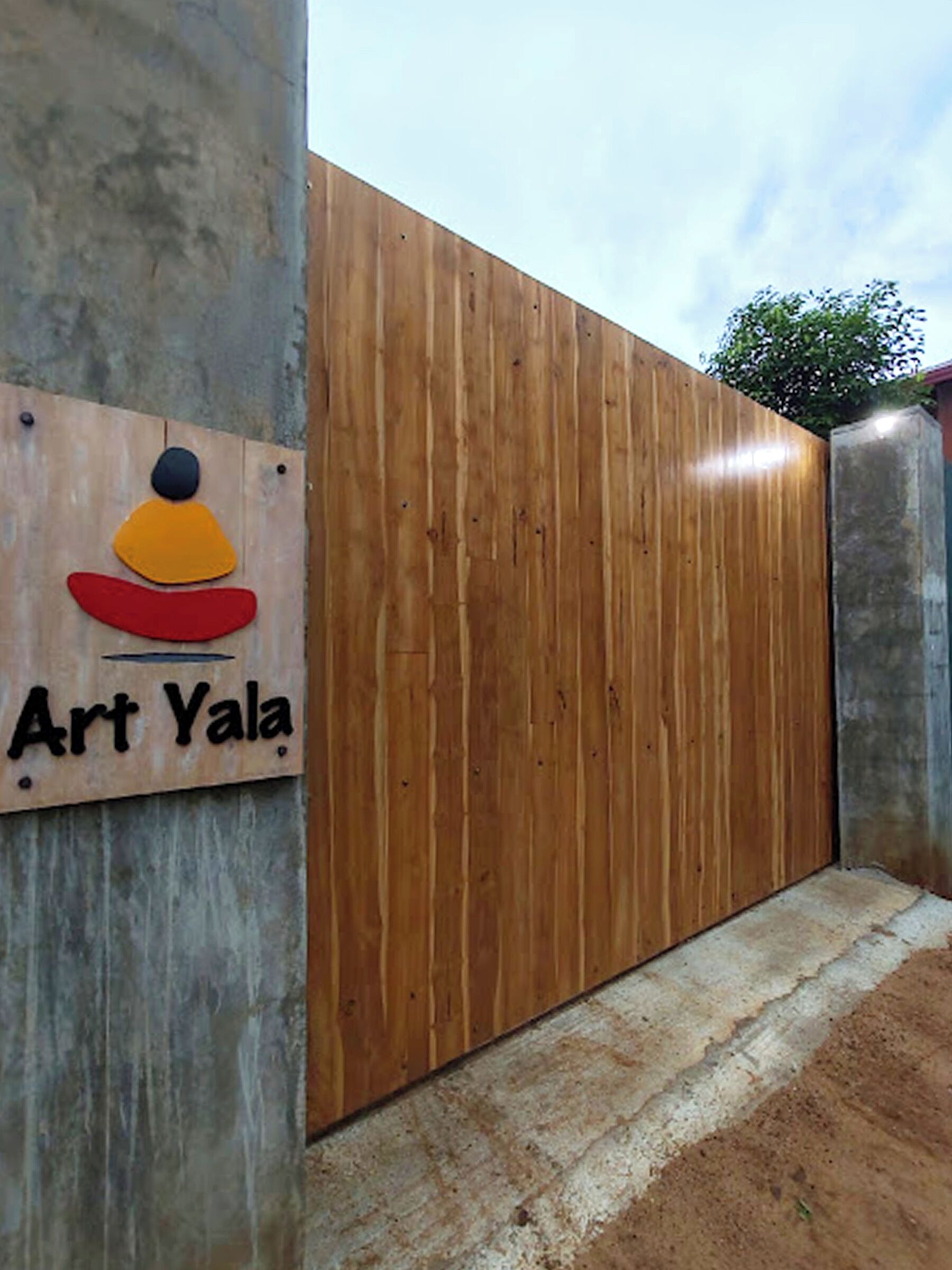 A wooden fence with a sign that reads "Art Yala".