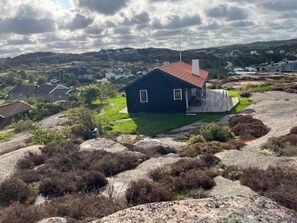 A house with a red roof, surrounded by rocky terrain and vegetation. - 4 Star Holiday Home in Bovallstrand (Bovallstrand)